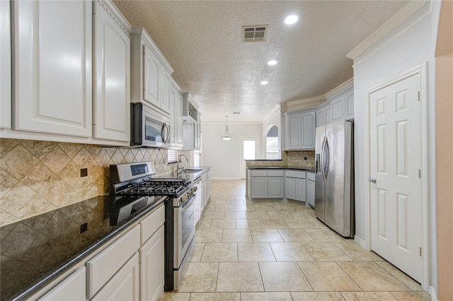 kitchen with stainless steel appliances, a sink, visible vents, white cabinets, and crown molding