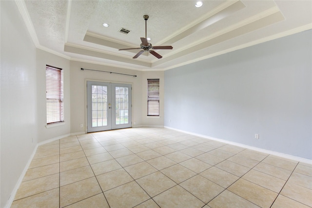 unfurnished room with visible vents, a raised ceiling, ornamental molding, a textured ceiling, and french doors