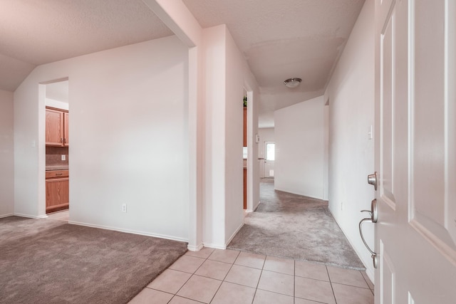 hall featuring a textured ceiling and light carpet