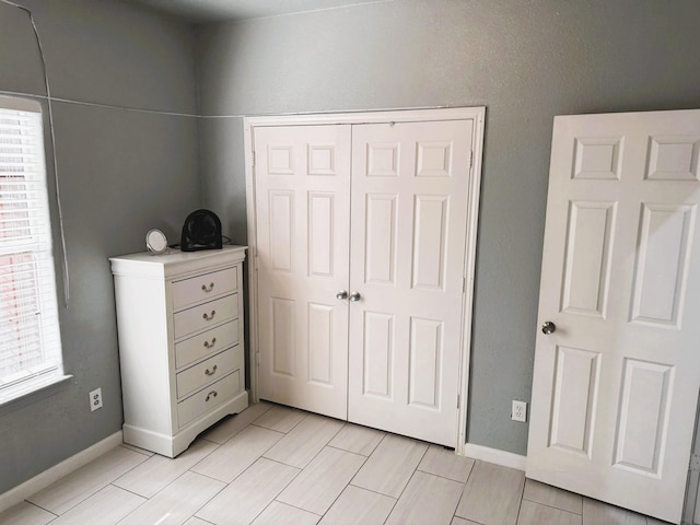 unfurnished bedroom featuring a closet and light tile patterned floors