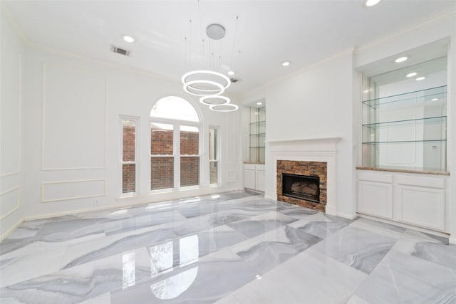 living room with a fireplace, a chandelier, built in features, and ornamental molding