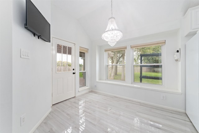 foyer featuring vaulted ceiling and a chandelier