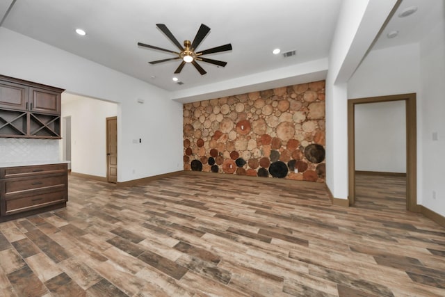 unfurnished living room featuring ceiling fan and dark hardwood / wood-style flooring