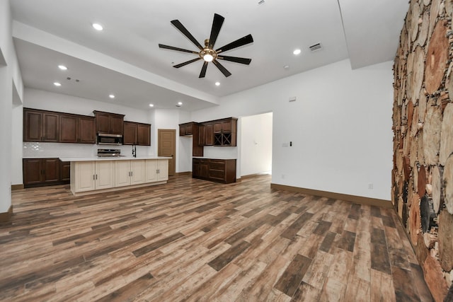 kitchen with ceiling fan, stainless steel appliances, dark hardwood / wood-style floors, a kitchen island, and cream cabinetry