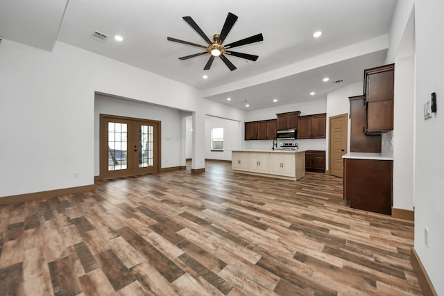 unfurnished living room featuring french doors, ceiling fan, and wood-type flooring