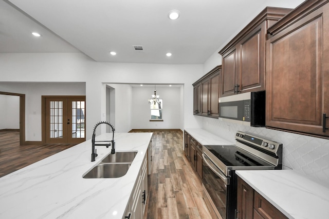 kitchen with sink, backsplash, stainless steel range with electric cooktop, light stone counters, and french doors