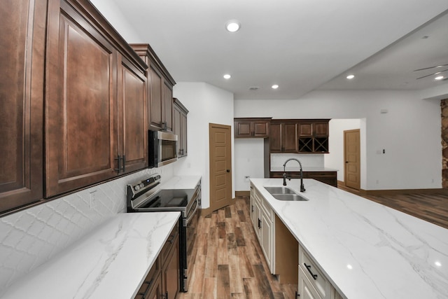 kitchen featuring appliances with stainless steel finishes, white cabinetry, sink, decorative backsplash, and light hardwood / wood-style floors