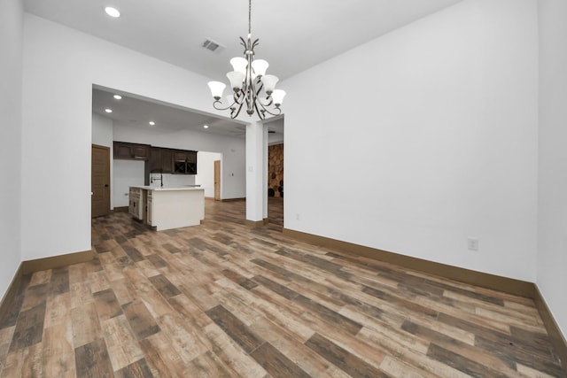 unfurnished living room featuring dark hardwood / wood-style floors and a chandelier