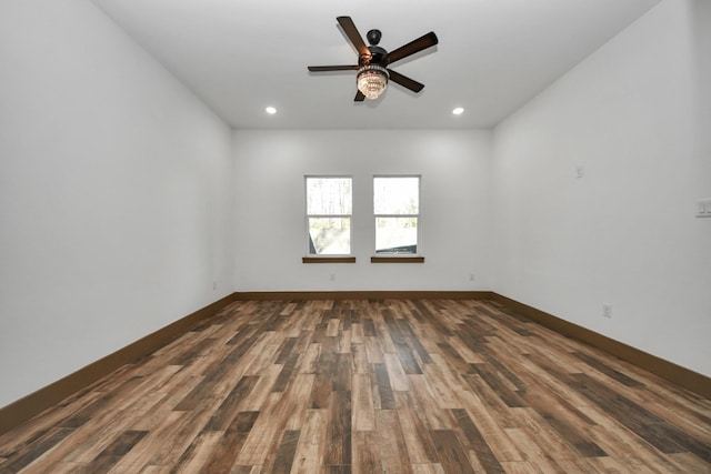 spare room featuring dark wood-type flooring and ceiling fan