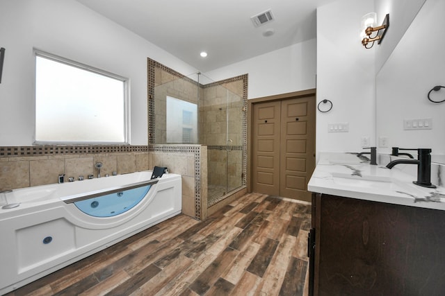 bathroom featuring vanity, hardwood / wood-style floors, and plus walk in shower