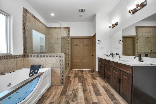 bathroom featuring vanity, separate shower and tub, and hardwood / wood-style floors