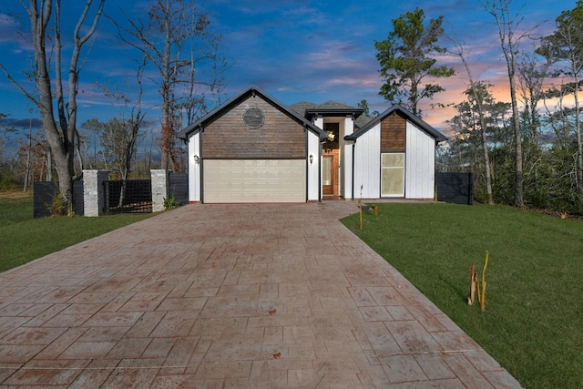 view of front of home with a garage and a lawn