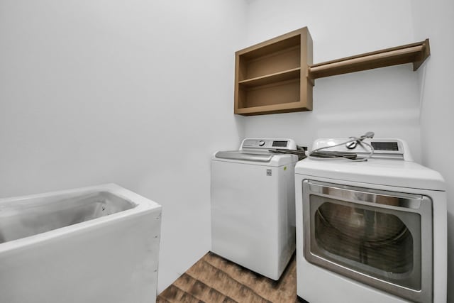 laundry area with separate washer and dryer and dark hardwood / wood-style flooring