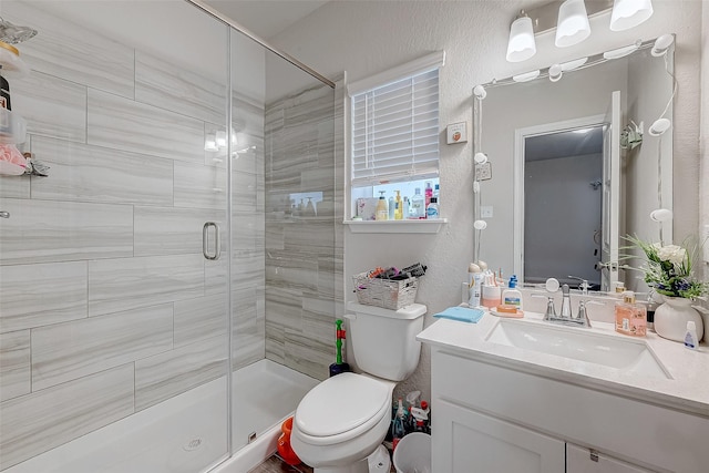 bathroom with toilet, vanity, and an enclosed shower