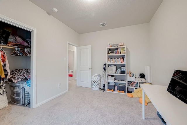 carpeted home office featuring a textured ceiling