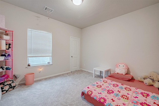 carpeted bedroom featuring a textured ceiling and multiple windows