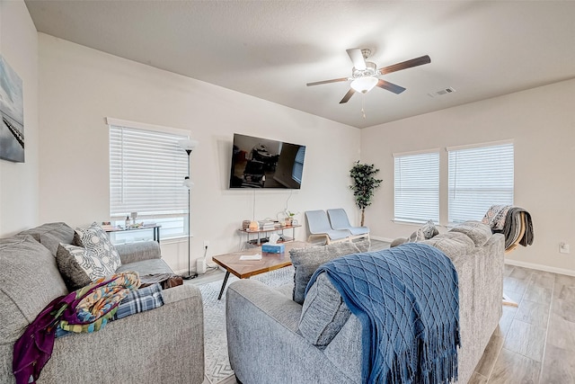 living room with ceiling fan and light wood-type flooring