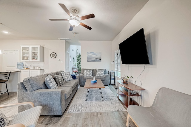 living room with light hardwood / wood-style floors and ceiling fan