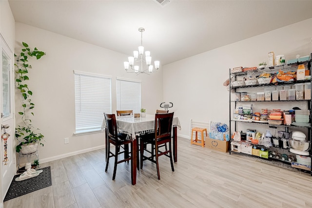 dining room featuring light wood-type flooring and a notable chandelier