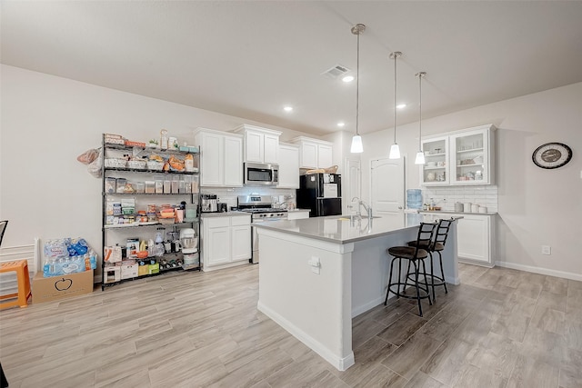 kitchen featuring sink, white cabinets, stainless steel appliances, and tasteful backsplash