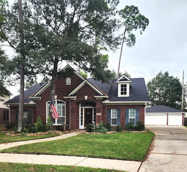 view of front of home featuring an outbuilding, a garage, and a front lawn