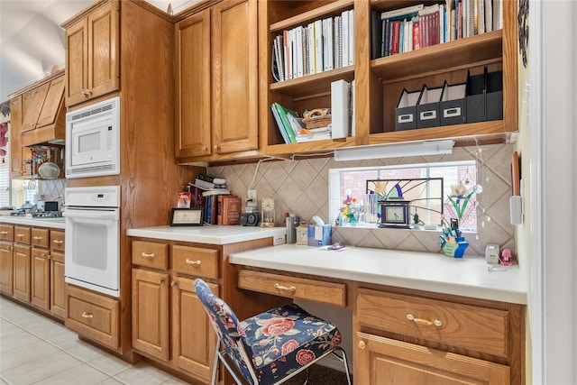 kitchen featuring tasteful backsplash, light tile patterned flooring, and white appliances