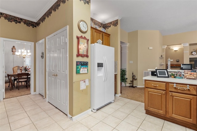 kitchen with crown molding, white fridge with ice dispenser, light tile patterned floors, and a notable chandelier