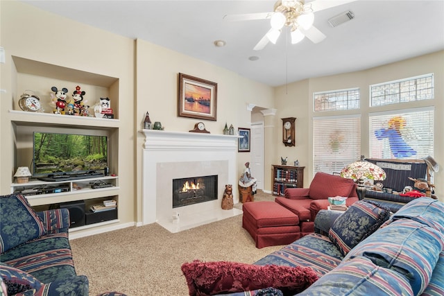 living room with carpet floors, built in features, ceiling fan, and ornate columns