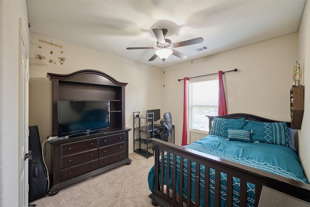 carpeted bedroom with a textured ceiling, visible vents, and ceiling fan