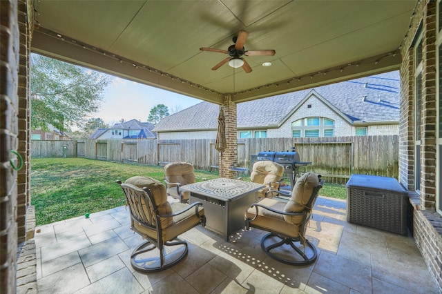 view of patio with a fire pit, a fenced backyard, and ceiling fan