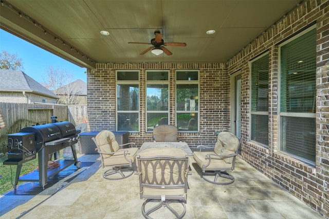 view of patio featuring area for grilling, fence, and ceiling fan