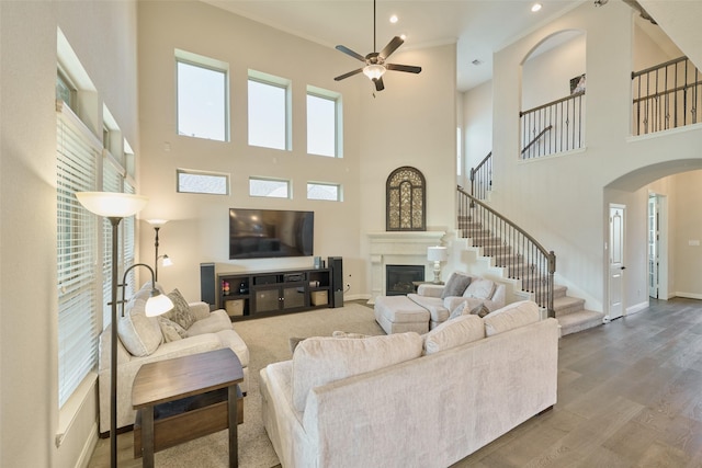 living room with a towering ceiling, a wealth of natural light, and hardwood / wood-style flooring