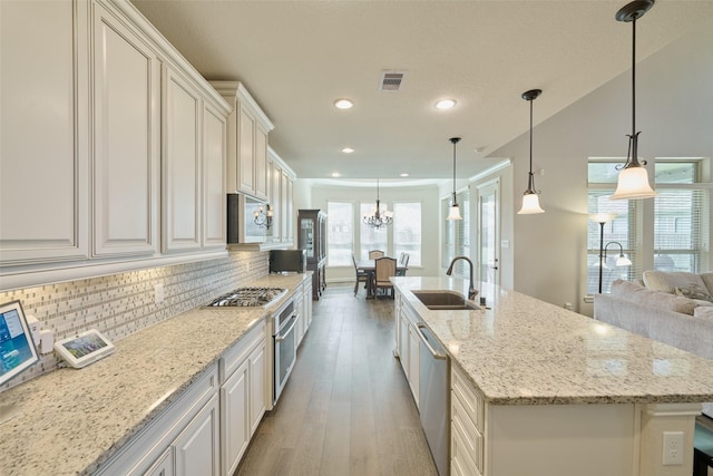 kitchen with tasteful backsplash, hanging light fixtures, a spacious island, and stainless steel appliances