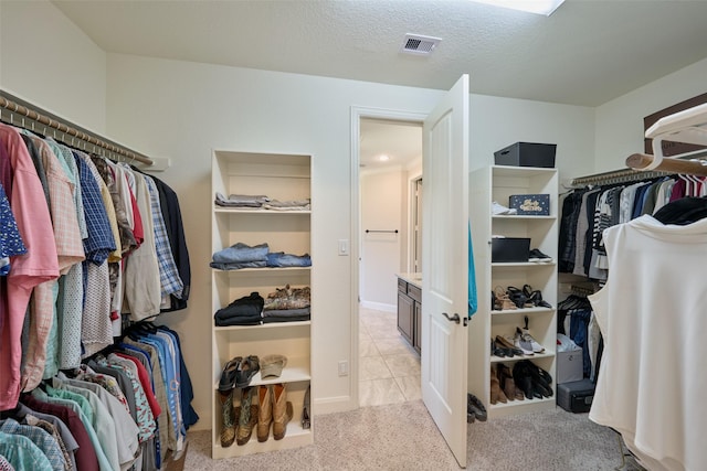 walk in closet featuring light carpet