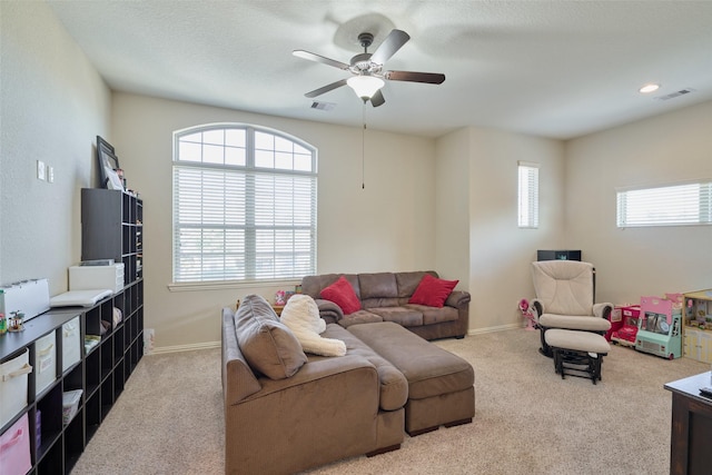 carpeted living room featuring visible vents, baseboards, and a ceiling fan