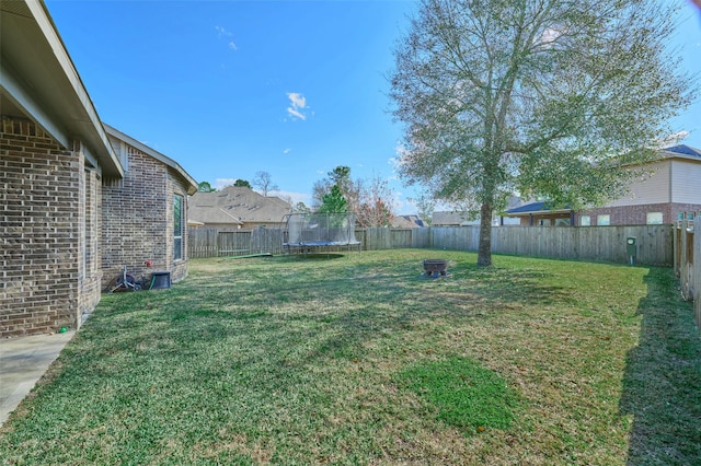 view of yard featuring a trampoline and a fenced backyard