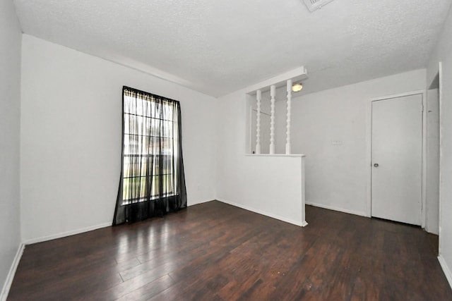 unfurnished room featuring a textured ceiling and dark hardwood / wood-style flooring