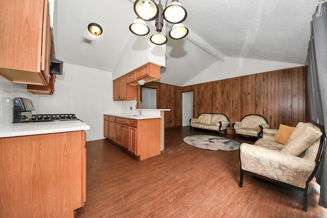 kitchen with dark wood-type flooring, a chandelier, lofted ceiling with beams, and stove