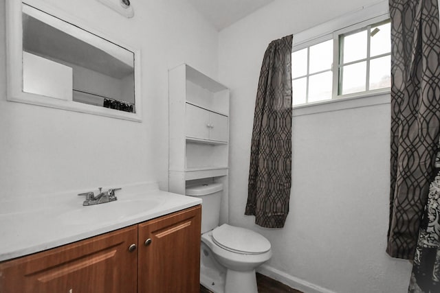 bathroom featuring toilet, vanity, and hardwood / wood-style floors