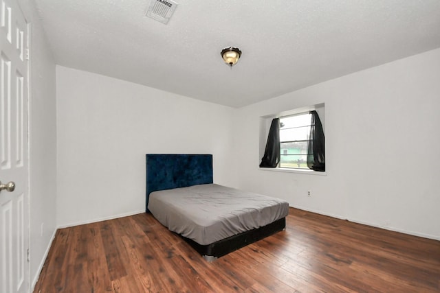 bedroom with dark hardwood / wood-style floors