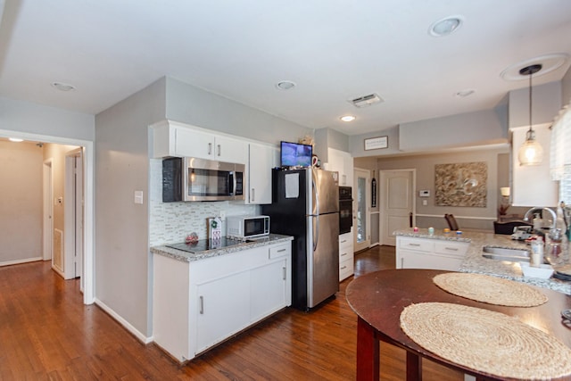 kitchen featuring sink, appliances with stainless steel finishes, white cabinets, and hanging light fixtures