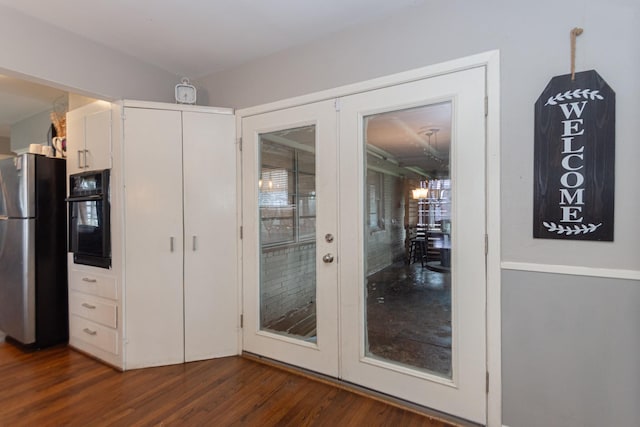 kitchen with french doors, dark wood-type flooring, stainless steel fridge, oven, and white cabinets