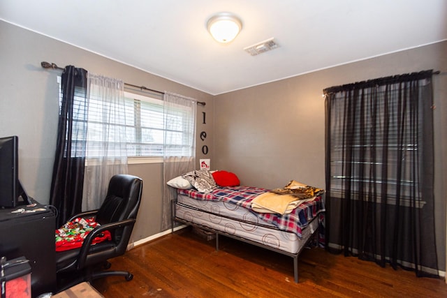 bedroom with dark hardwood / wood-style flooring