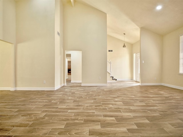 unfurnished living room featuring high vaulted ceiling