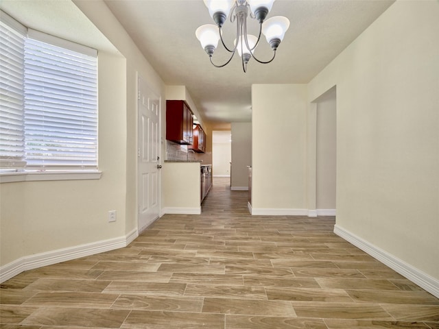 unfurnished dining area featuring a notable chandelier and light wood-type flooring