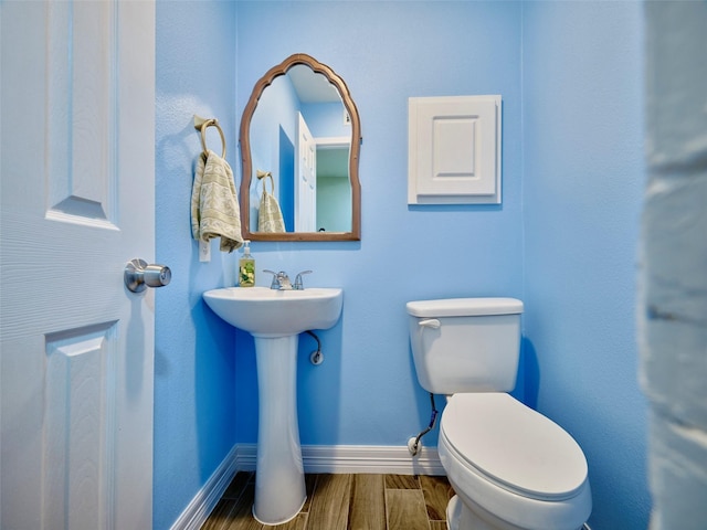 bathroom with toilet and hardwood / wood-style floors