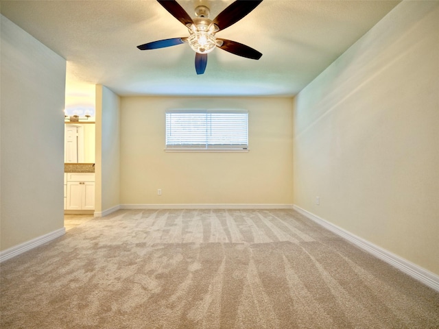 spare room featuring ceiling fan and light colored carpet