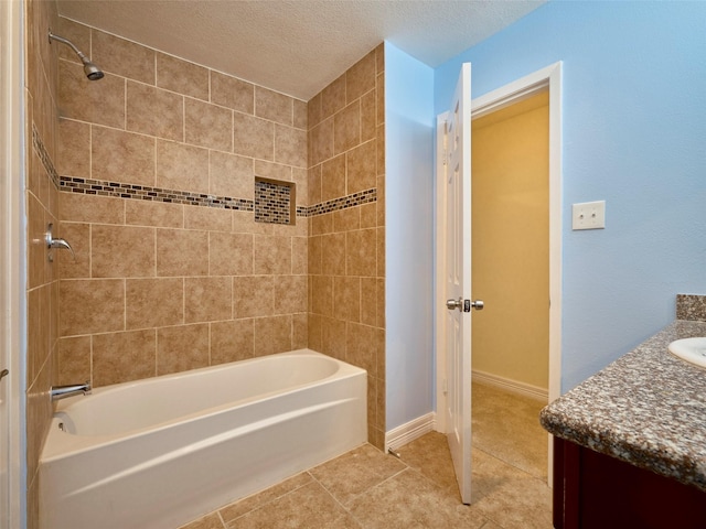 bathroom featuring a textured ceiling, tiled shower / bath combo, tile patterned floors, and vanity