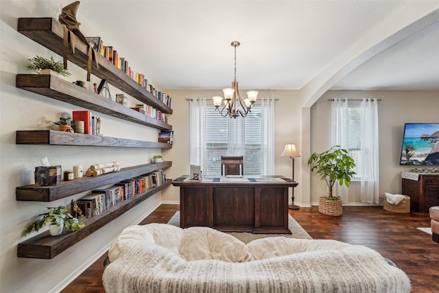 home office with dark wood-type flooring and a chandelier