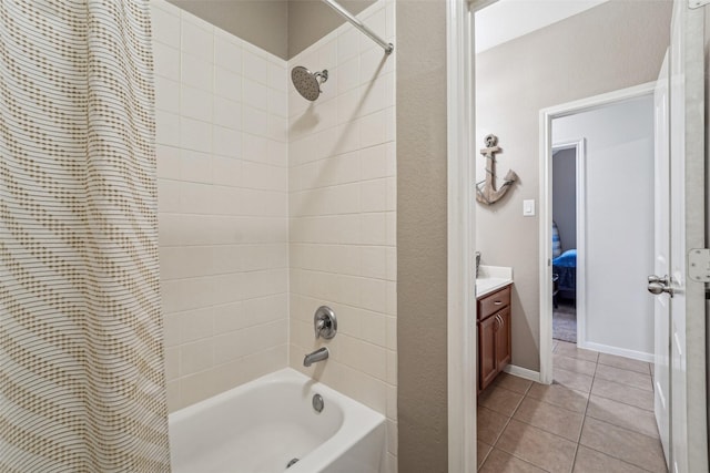 bathroom featuring tiled shower / bath combo, vanity, and tile patterned flooring